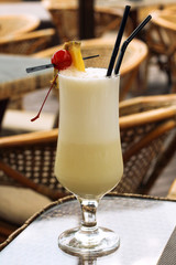 Milk cocktail  on the wooden table on a  the background of blurry tables and chairs