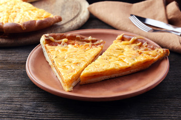 Slices of tasty cheese pizza on plate close up