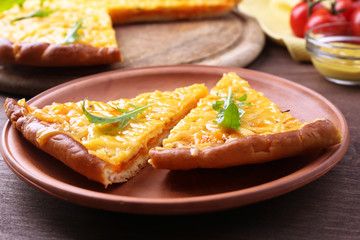Slices of tasty cheese pizza with arugula and vegetables on table close up