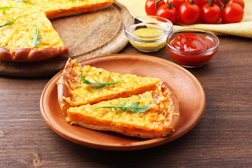 Slices of tasty cheese pizza with arugula and vegetables on table close up