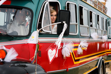 Fototapeta premium beautiful gorgeous blonde bride and stylish groom in the decorated bus, wedding ceremony on cyprus
