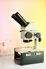 Test tubes and microscope on bright background