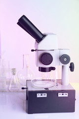 Test tubes and microscope on bright background