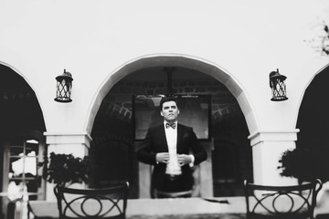 stylish rich groom standing near chair montenegro black and whit