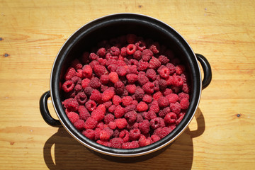 Bowl of raspberries on wooden plank