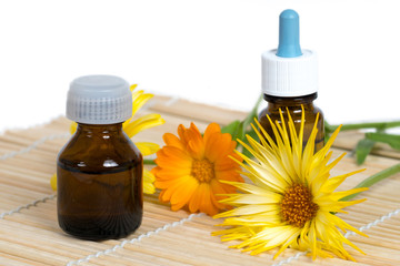 two bottle and calendula flowers on bamboo plate