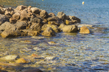 Yellow rocks on transparent turquoise water on a coastal scene