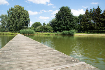 Fototapeta na wymiar wooden footbridge / old wooden footbridge over a pond