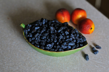Honeysuckle in green bowl  with peaches on a table