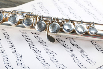 Fototapeta premium Silver flute on music notes background