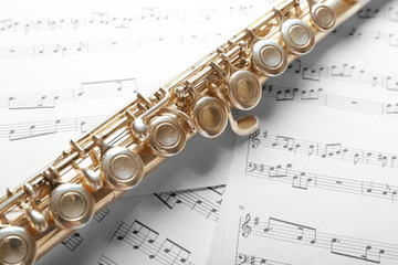 Naklejka premium Silver flute on music notes background