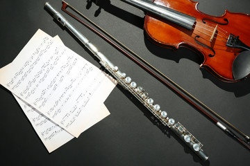 Fototapeta premium Violin and flute with music notes on dark background