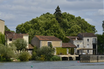 Fototapeta na wymiar Vieilles bâtisses au bord de la Charente devant la colline du grand parc de Jarnac