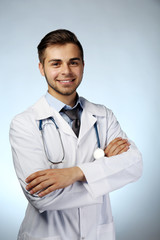 Male doctor with stethoscope on blue background