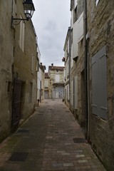 Fototapeta na wymiar Ruelle étroite et sombre dans la partie médiévale de Saintes 