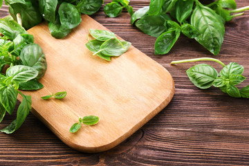 Green fresh basil on wooden background