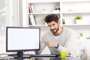 Businessman portrait. Young businessman showing the white computer screen at office.