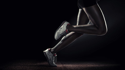 Sports background. Runner. Side view of a jogger legs isolated on black
