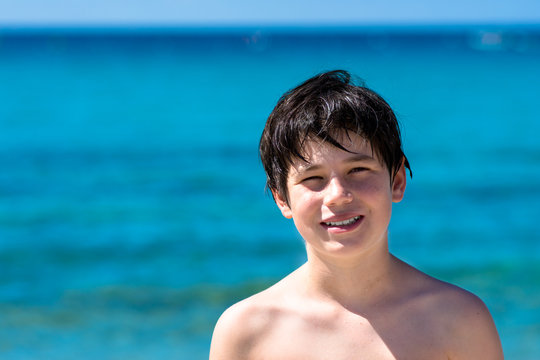 Happy smiling little girl on beach vacation, blu sea background