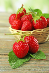 Ripe strawberries with leaves on wooden table, closeup