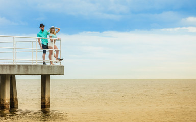 Loving hipster couple on sea pier
