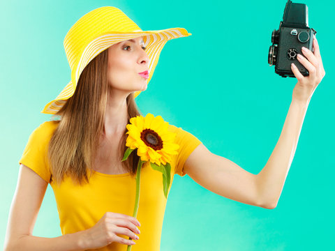 Summer woman holds sunflower old camera