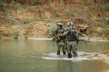 Naklejka premium Military team crossing the river under fire