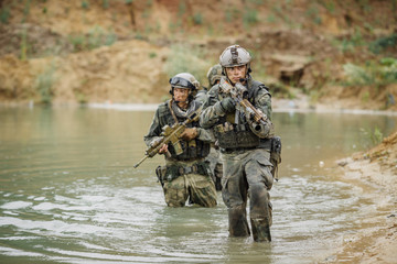 Naklejka premium Military team crossing the river under fire