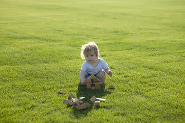 Naklejka na ściany i meble Little baby boy on green lawn