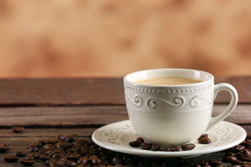 Cup of coffee and beans on blurred background