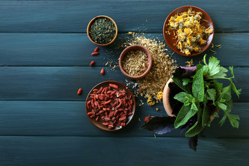 Herbs, berries and flowers on color  wooden table background