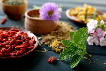 Herbs, berries and flowers on color  wooden table background