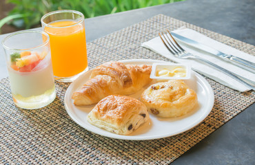 bread and orange juice on breakfast set