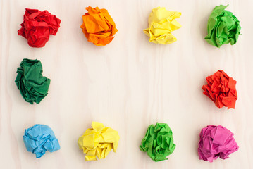 Colored paper balls isolated on wooden background .