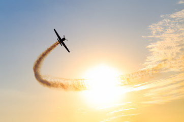 Silhouette of an airplane performing flight at airshow at sundown