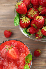 Glass of strawberry smoothie with berries on table close up