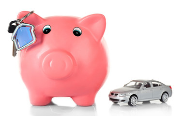 Piggy bank with toy car and key isolated on white