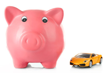 Piggy bank with toy car isolated on white