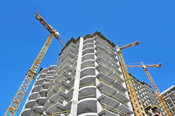 Crane and building construction site against blue sky