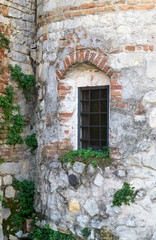Fototapeta na wymiar old window grille of a ruined castle