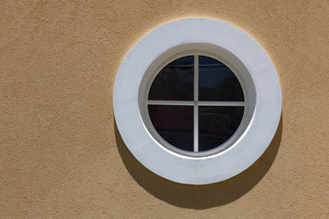 Circle white window on the texture wall. With small shadow.