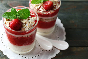 Dessert with fresh strawberry, cream and granola, on wooden table background