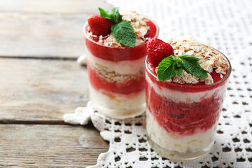 Dessert with fresh strawberry, cream and granola, on color wooden table background