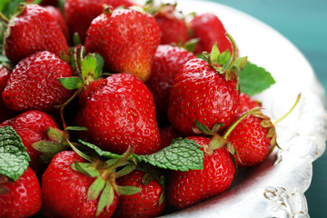 Red ripe strawberries on tray, on color wooden background