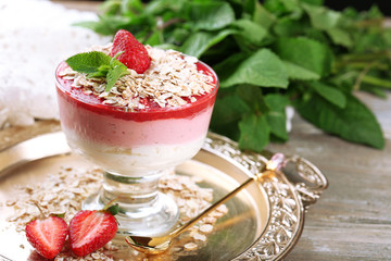 Dessert with fresh strawberry, cream and granola, on wooden table background
