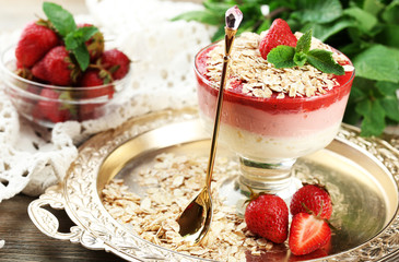 Dessert with fresh strawberry, cream and granola, on wooden table background