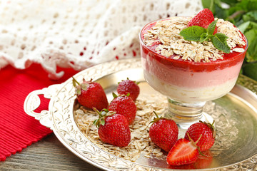 Dessert with fresh strawberry, cream and granola, on wooden table background