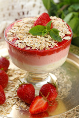 Dessert with fresh strawberry, cream and granola, on wooden table background