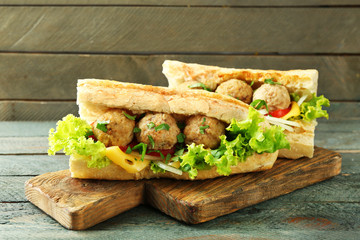 Homemade Spicy Meatball Sub Sandwich on wooden table background
