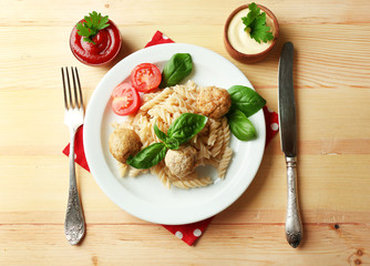 Pasta with meatballs on plate, on wooden  table background